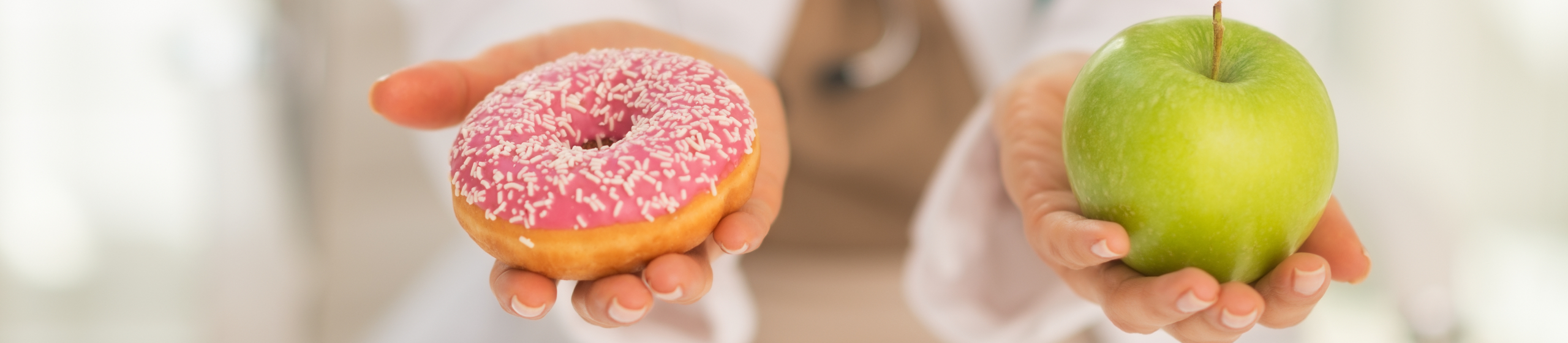 Krupni plan na lekarku koja bira između jabuke i krofne