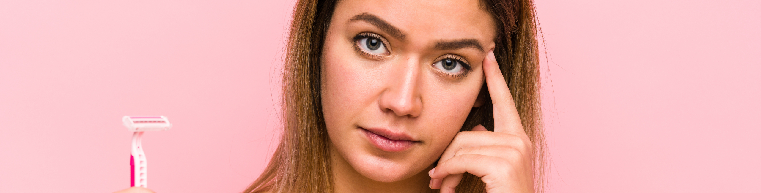 Mlada žena drži brijač i izgleda zabrinuto